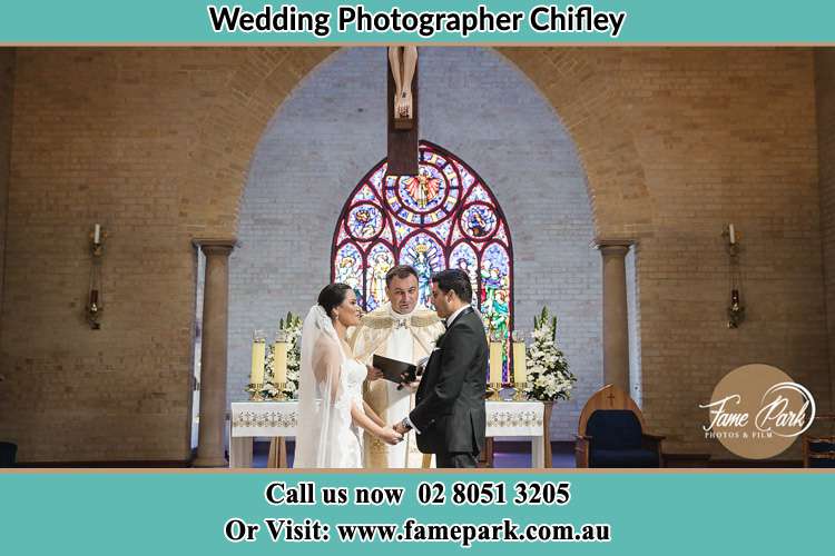 Photo of the Bride and the Groom with the Priest at the altar Chifley NSW 2036