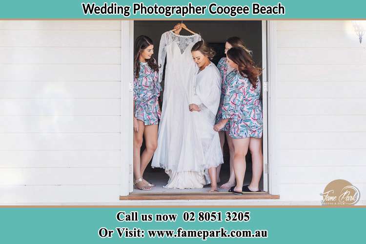 Photo of the Bride and the bridesmaids checking the wedding gown at the door Coogee Beach NSW 2034